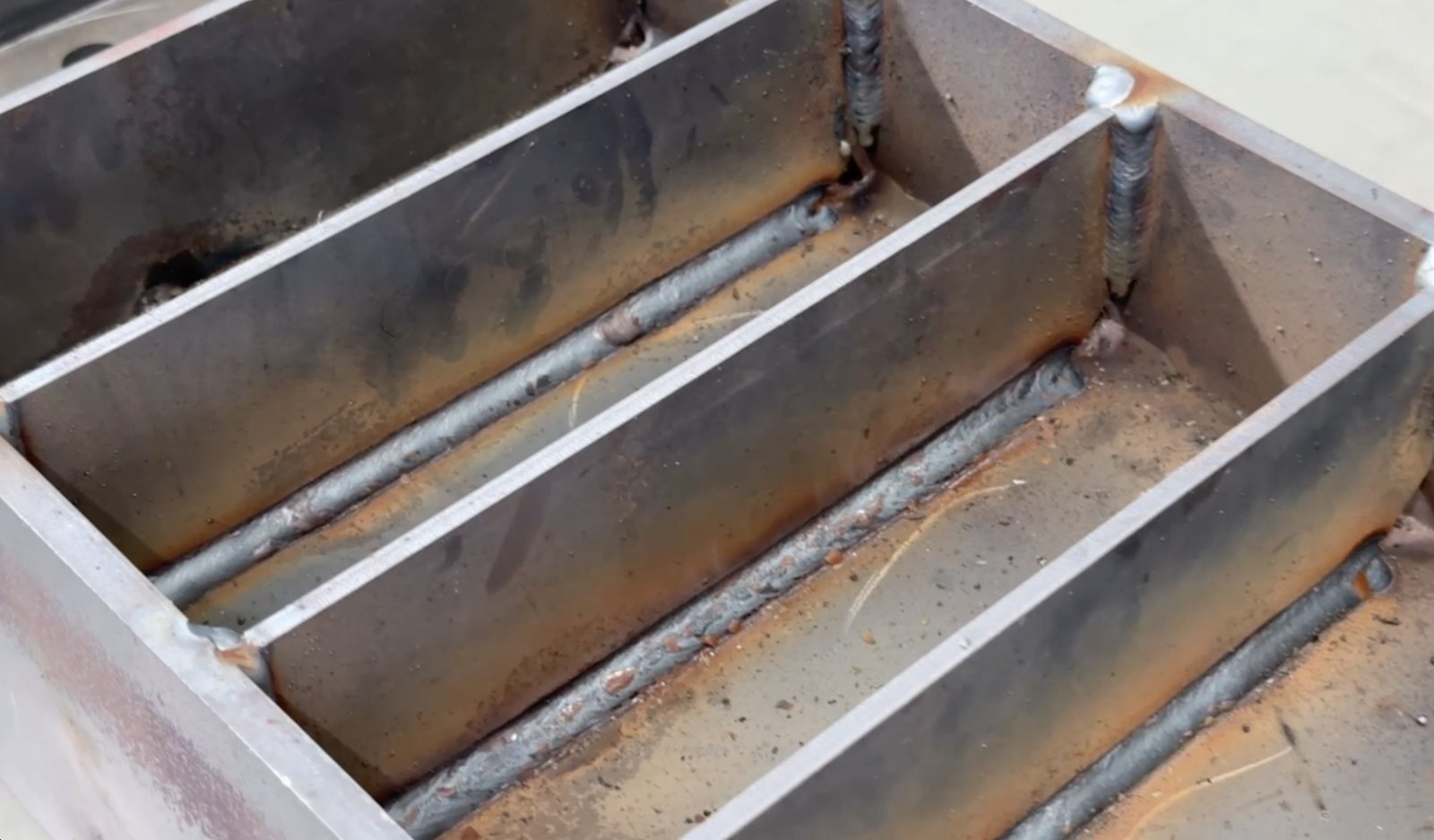 Close-up of finished robotic weld beads on a fabricated steel assembly